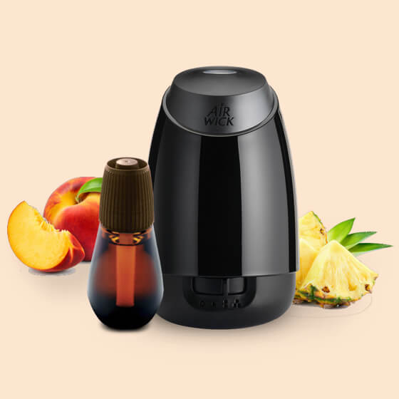 Présente un diffuseur et une recharge Essential Mist® parmi des tranches de pêche et d'ananas.