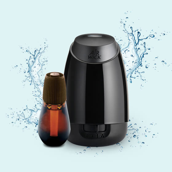 Présente un diffuseur et une recharge Essential Mist® parmi de l’eau éclaboussant.