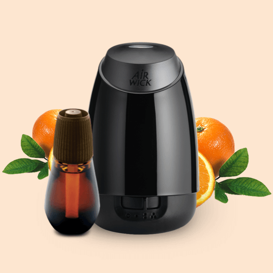 Présente un diffuseur et une recharge Essential Mist® parmi des tranches de mandarine douces.